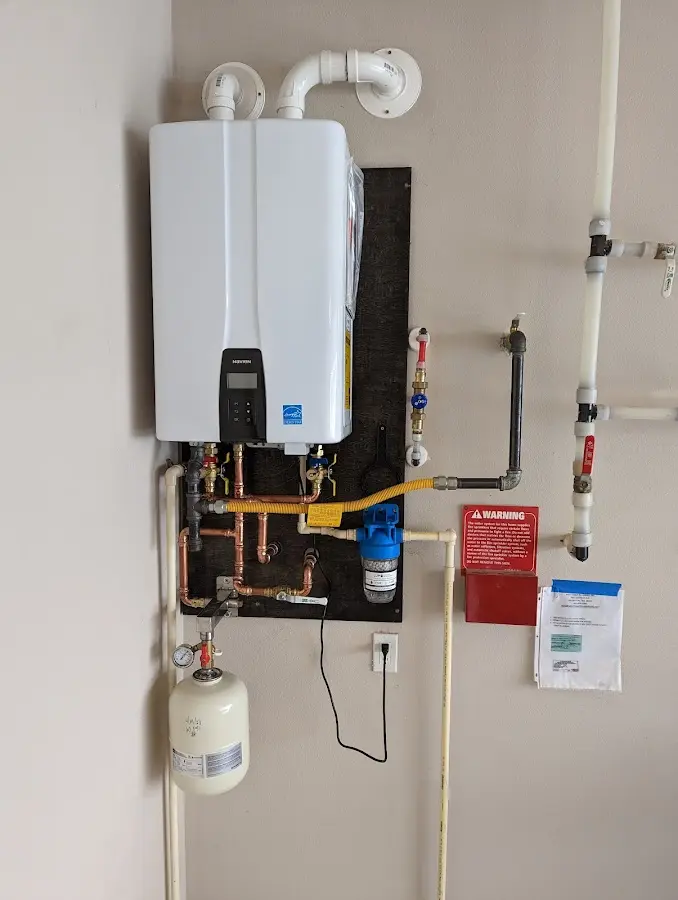 Professional plumber installing copper piping in a Maine home